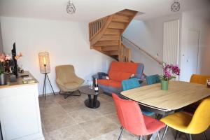 a living room with a table and colorful chairs at Au logis de Bayard in Vareilles