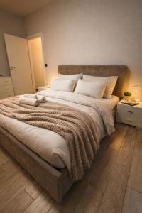 a large bed with a blanket and pillows on it at Oasi Domese Appartamento Centrale in Domodossola