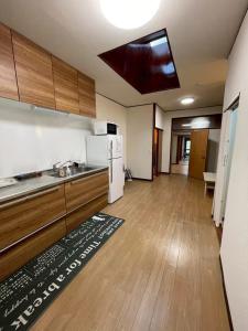 a room with a kitchen with a refrigerator and a table at Modern style old house in Nagoya