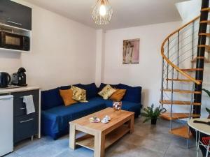 a living room with a blue couch and a table at Sibiti, charmant 2 pièces à 20 minutes de Paris in Le Blanc-Mesnil +14 photos