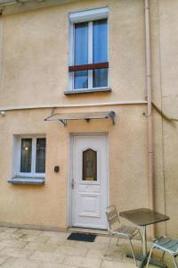 a building with a door and a table in front of it at Sibiti, charmant 2 pièces à 20 minutes de Paris in Le Blanc-Mesnil