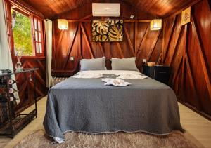 a bedroom with a large bed with wooden walls at Pousada do Xerife in Caconde +94 photos