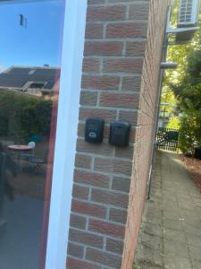 a brick wall with two speakers on the side of a house at Studio confortable situé à Woluwe Saint Lambert in Brussels