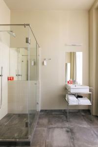a bathroom with a glass shower and a sink at Esqina Cosmopolitan Lodge in Lisbon