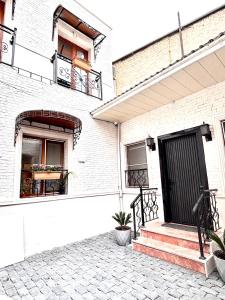 a white brick house with a black door and stairs at JM Central Boutique Hotel in Baku
