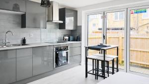 a kitchen with stainless steel appliances and a window at AMETHYST - 4br all with ensuite & parking in Cambridge