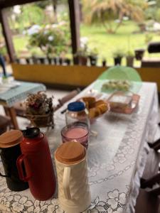 a table with a white table cloth with food and drinks at Pesqueiro & Pousada Beatriz in Piedade