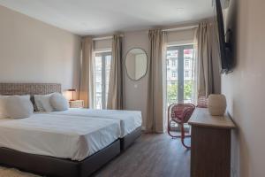 a bedroom with a large bed and a mirror at Uma Poveiros in Porto
