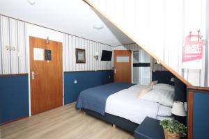 a bedroom with a large bed and a staircase at Hotel Restaurant de Boekanier in Vrouwenpolder