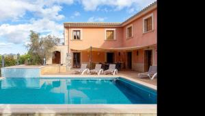 a villa with a swimming pool in front of a house at Son Monget in Muro