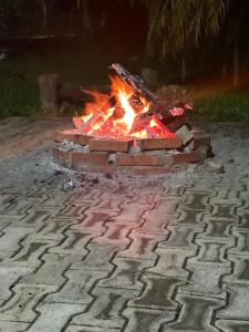 a brick fire pit on a cobblestone street at Pesqueiro & Pousada Beatriz in Piedade