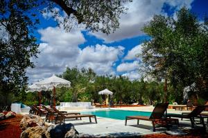 a swimming pool with chairs and umbrellas next to it at Case Fra Gli Ulivi in Spongano