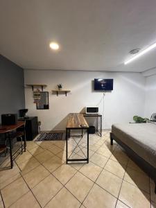 a room with a bed and a table and a tv at Estudio in Zamora de Hidalgo
