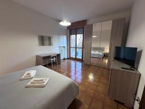a bedroom with a bed and a television and a desk at Hospital - WI-FI 3 Bedrs in Reggio Emilia