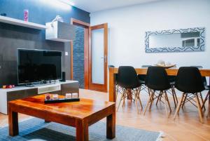 a living room with a tv and a table and chairs at Bird’s Home in Aveiro