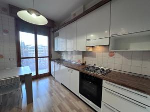 a kitchen with white cabinets and a black stove top oven at Hospital - WI-FI 3 Bedrs in Reggio Emilia