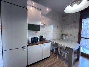 a kitchen with white cabinets and a table with a microwave at Hospital - WI-FI 3 Bedrs in Reggio Emilia