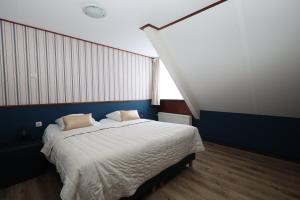 a bedroom with a large bed with a blue wall at Hotel Restaurant de Boekanier in Vrouwenpolder