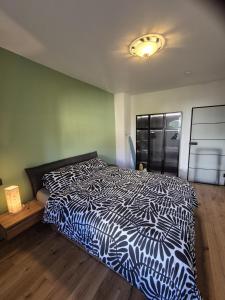 a bedroom with a bed with a black and white comforter at FeWo Altstadt in Stralsund