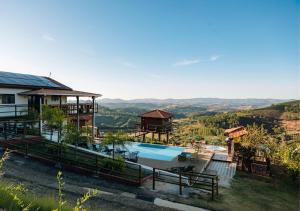 a resort with a swimming pool and mountains in the background at Pousada do Xerife in Caconde