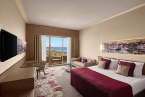 a hotel room with a bed and a television at Concorde Luxury Resort & Casino in Vokolidha