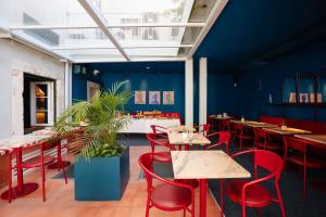 a restaurant with red chairs and tables and blue walls at Esqina Cosmopolitan Lodge in Lisbon