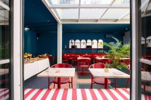 a restaurant with red chairs and tables in a room at Esqina Cosmopolitan Lodge in Lisbon