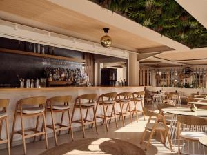 a restaurant with a bar with chairs and tables at Nemesis Aparthotel in Laganas