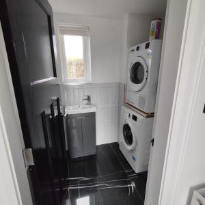 a small bathroom with a washing machine and a washer at An Camus Ballyliffin in Ballyliffin