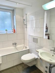 a white bathroom with a toilet and a sink at Art studio 64 in Basel +22 photos