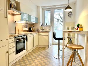 a kitchen with white cabinets and a checkered floor at Art studio 64 in Basel
