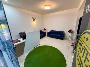 a waiting room with a blue couch and a green rug at Hotal zora in Rohtak +14 photos