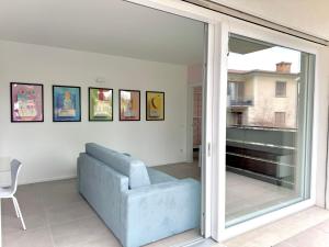 a living room with a blue couch and a sliding glass door at Pantone - Sarnico Color Suites in Sarnico