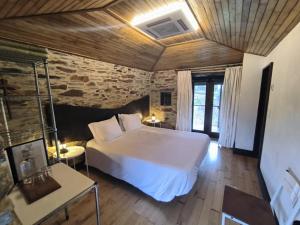a bedroom with a large white bed in a room at Casa do Porco - Farm Stay & Spa no Douro in Melres