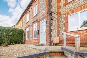 a brick building with a white door on it at 4 Bed in Sheringham oc-m28357 in Sheringham