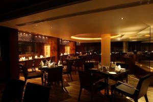 a restaurant with tables and chairs and a bar at Paradigm Sarovar Portico in Kākināda