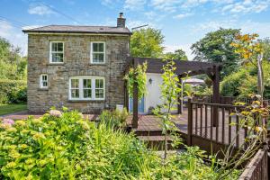 a stone house with a porch and a fence at 2 Bed in Blackmill oc-c29623 in Brynmenin