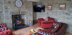 a living room with two chairs and a fireplace at Ffyllon Fawr in Henfynyw Upper