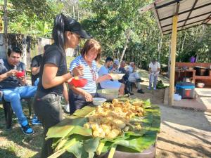 a group of people standing around a table with food at Cabañas Villa Raizal in Guaduas