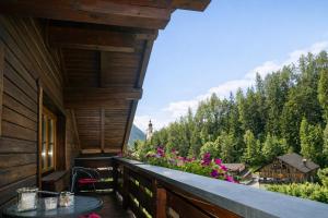 a balcony of a log cabin with a table and flowers at Apartment Fischer in Tarrenz