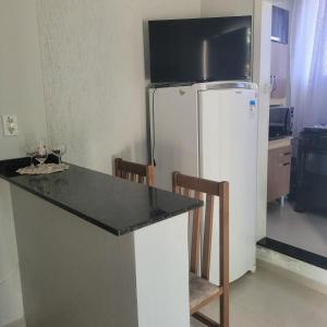 a kitchen with a refrigerator and a table with chairs at Apartamento in União da Vitória