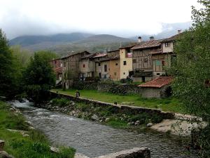 a river in a town with buildings next to a river at El Mirador de Hervas in Hervás
