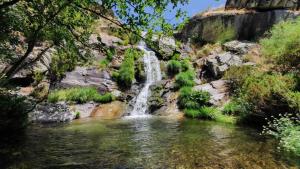 a waterfall in the middle of a pool of water at El Mirador de Hervas in Hervás