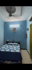 a blue bedroom with a bed with a blue wall at Unique Stays in Pondicherry
