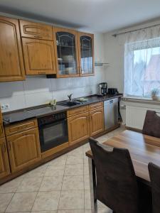 a kitchen with wooden cabinets and a wooden table at Schöne, große Wohnung mit 3 Betten in Bramsche