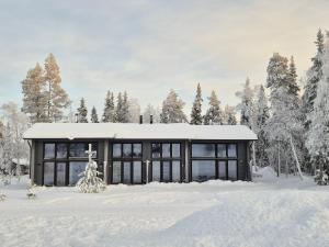 a house in the snow with snow covered trees at Deluxe Luosto in Luosto