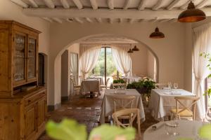 a dining room with two tables with white tablecloths at Castello Di Gabbiano in Mercatale Val Di Pesa
