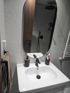 a white bathroom sink with a mirror and toothbrushes at loft in El Aouina Station +32 photos