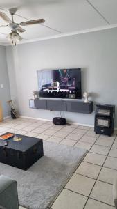 a living room with a flat screen tv on the wall at Riley's Place in Cape Town +9 photos