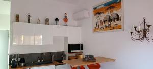 a kitchen with white cabinets and a table in it at Chez Christine et Marcel in Nans-les-Pins